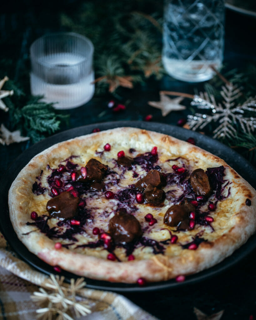 Pizza mit Rotkohl, Hirschgulasch und Granatapfelkernen vom Pizzastahl